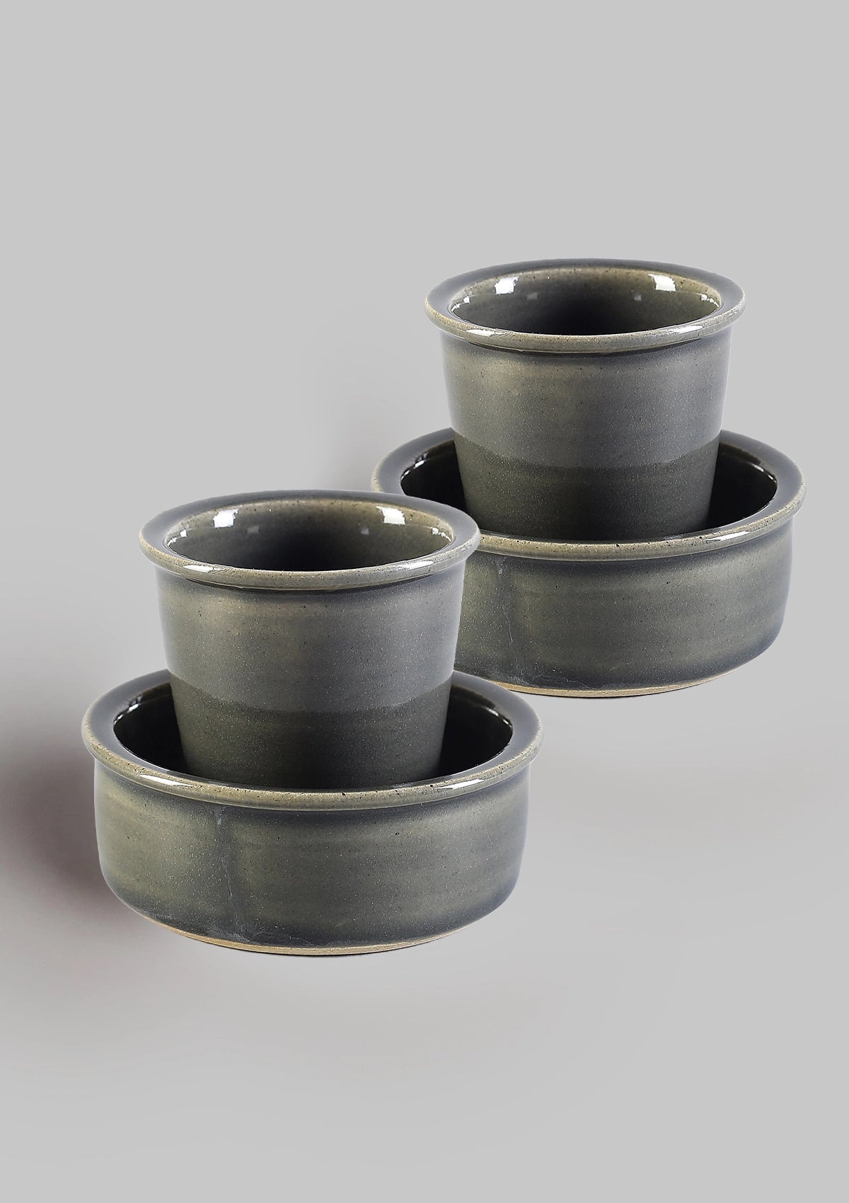 Set of three gray ceramic pots on a light gray background
