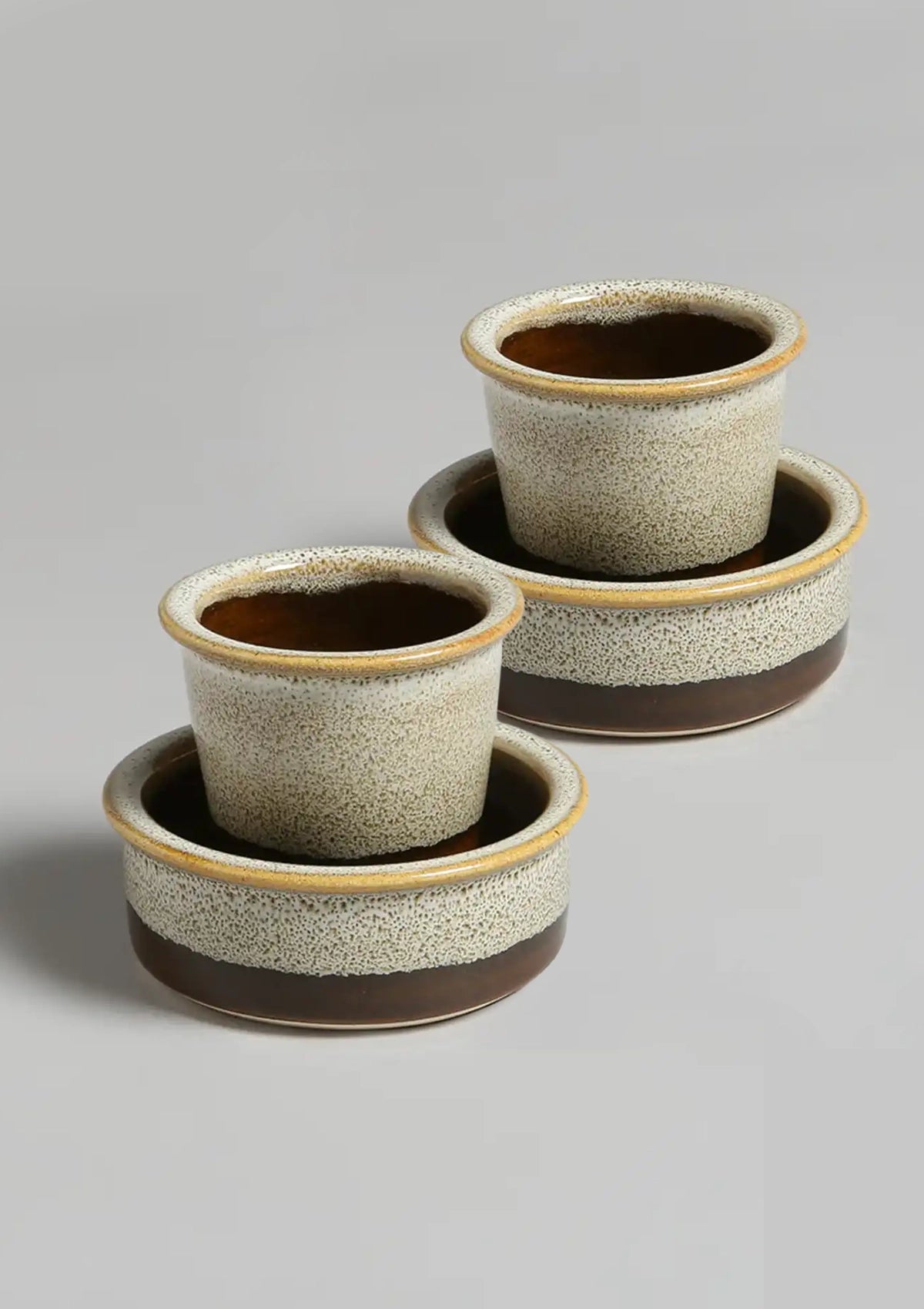 Set of two ceramic planters with brown and beige glaze on a gray background