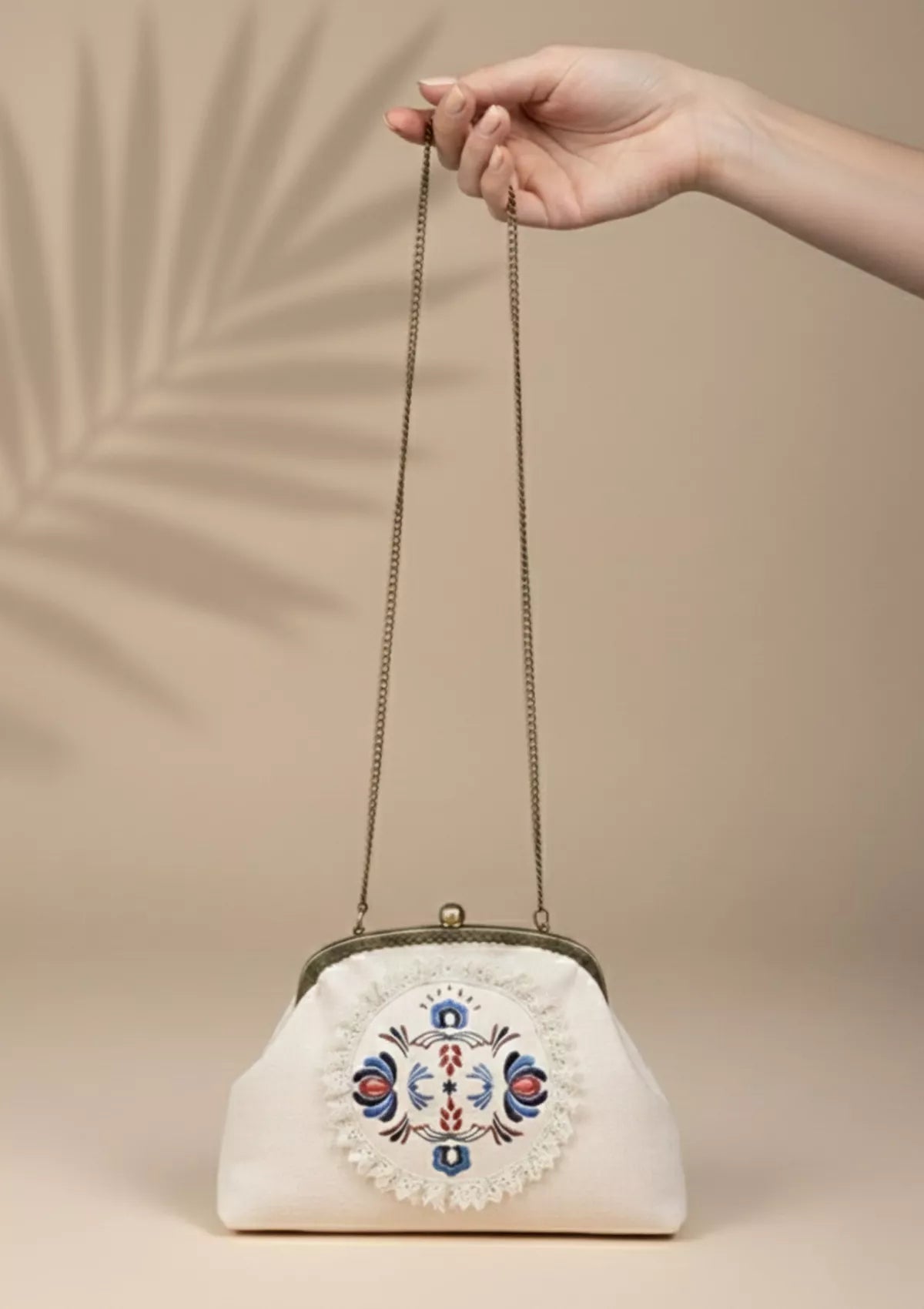Beige handheld clutch and sling bag