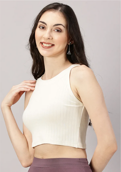 Model wearing ivory white ribbed halter top combined with mauve knit boot leg pants for a sophisticated airport look
